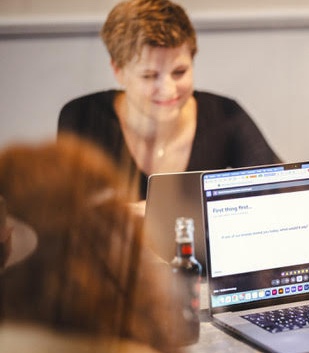 Wiebke Hungrichhaußen working at her laptop, reviewing a project with her team